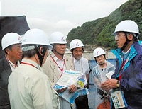  原発予定地を視察した国会議員５人（左側）の質問に答える中電社員（右）＝上関町長島の田ノ浦
