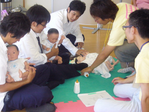 赤ちゃんを抱く男子高校生