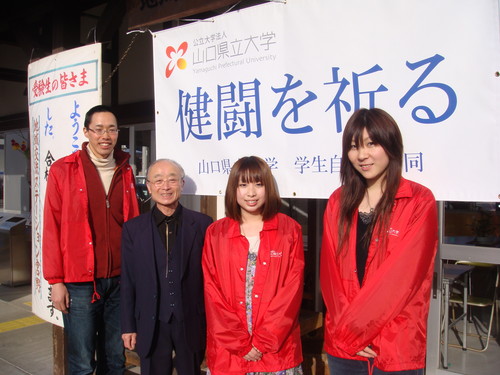 「健闘を祈る」の横断幕の前で