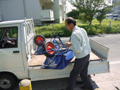 一輪車を荷積みする職員